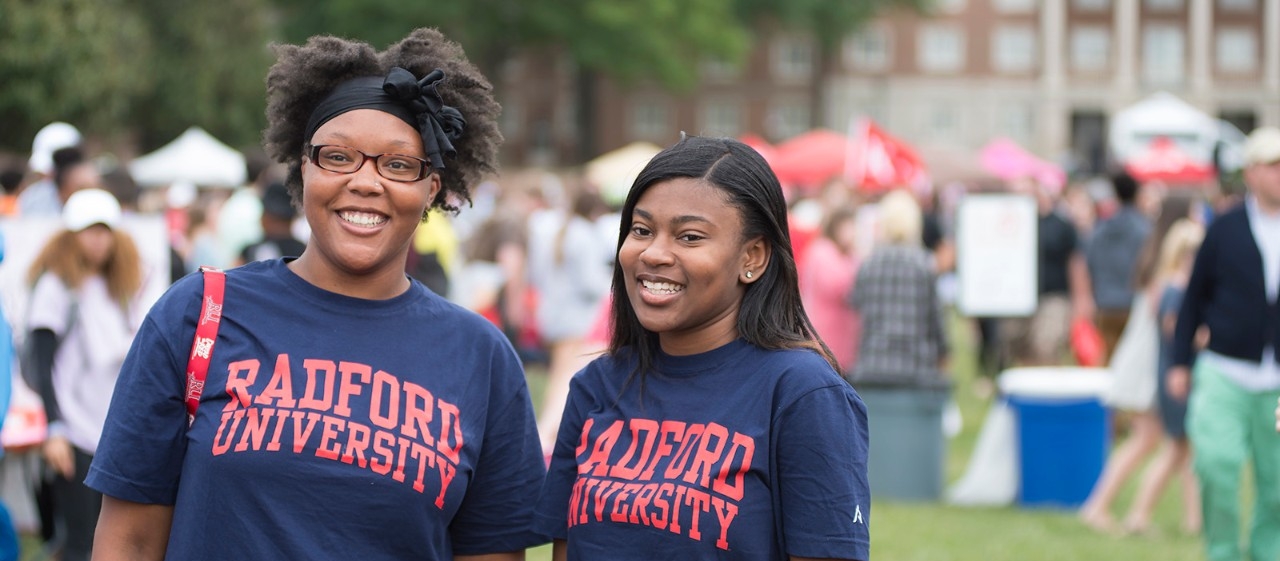 Two students wearing Radford University shirts and smiling
