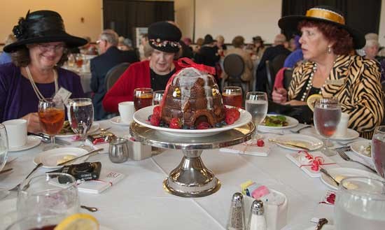 A beehive cake adorns the table as several attendees of the Women of Radford Luncheon chat.