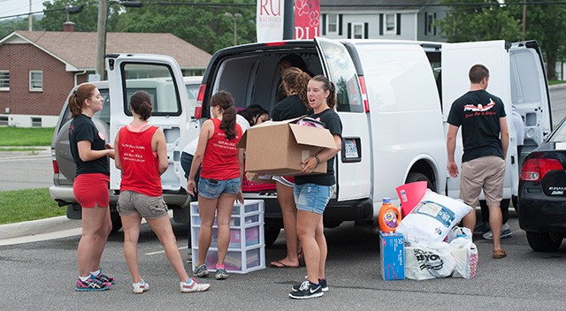 Members of the RU Swim Club help  unload dorm items for the family of Arial Johnson as they help them in the Move-In process.