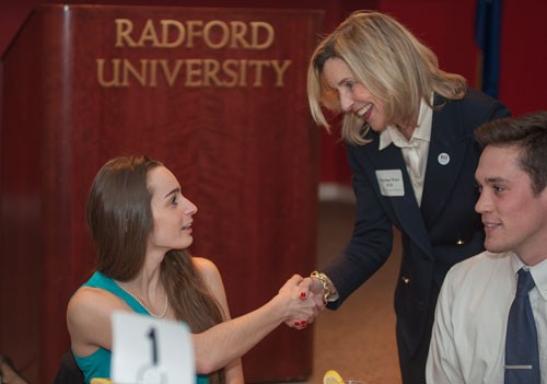 President Kyle demonstrates the proper way to introduce one's self at a dinner event as she shakes hands with Sarah Ponthieux