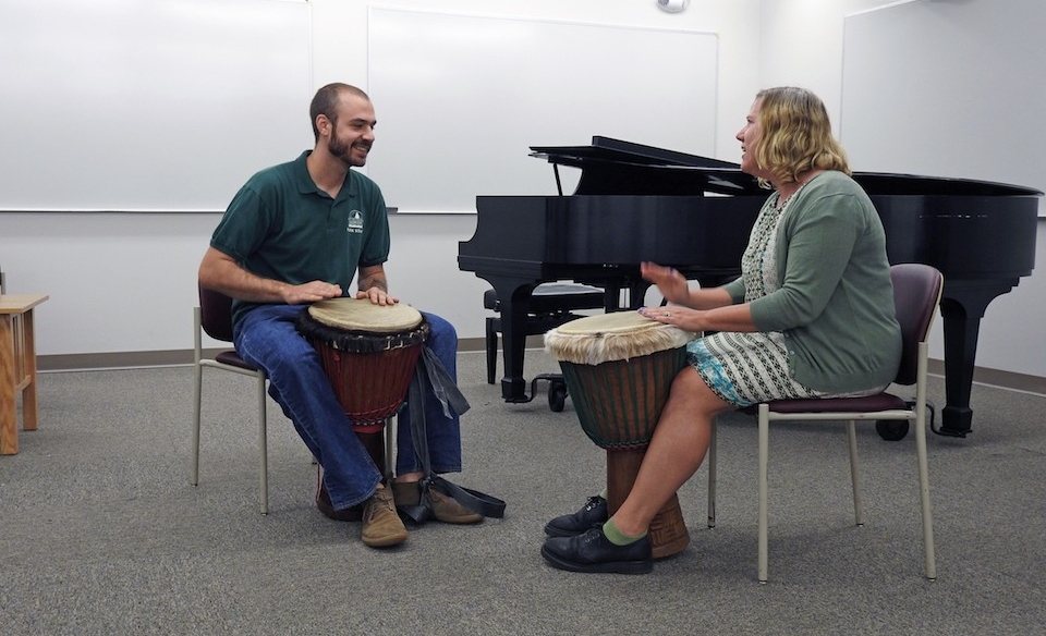 Anthony Kaseoru (left) and Trish Winter (right) play the djembe drums. 