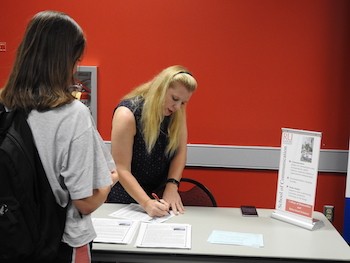 Associate Professor Lisa Baker Webster, center, explains the offerings in the School of Communication to a student.