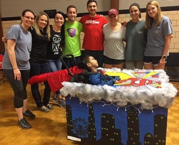 RU DPT second-year students celebrate the reveal of their assistive trick or treat costume they created for the Hallowheels competition with its recipient.