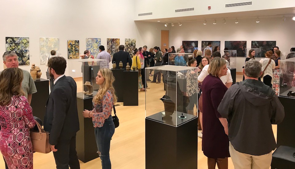 Observers view the BFA Exhibition in The Radford University Art Museum at the Covington Center