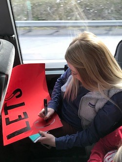 Makenzi Gallagher creates a sign while on the bus to Pittsburgh.