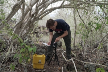 Senior biology major Conner Philson uses a spectrometer on Pinta Island