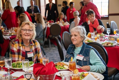 Linda Kitchel '69, left, and Barbara Moulder, right, enjoy the food during the alumni awards luncheon.