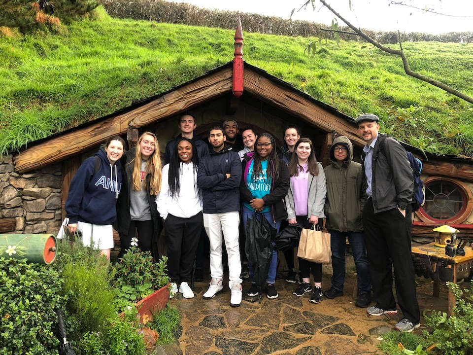 The study abroad group visited the set of the movie trilogy "The Lord of the Rings" and is pictured in front of a Hobbit Hole in Hobbiton. 