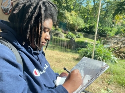 A student takes notes on primate behavior at a class at the NC Zoo.