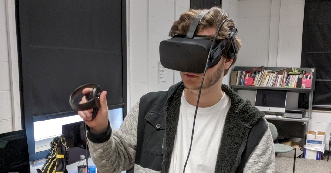 Junior graphic design student Michael Conway plays with a virtual reality rig during class.