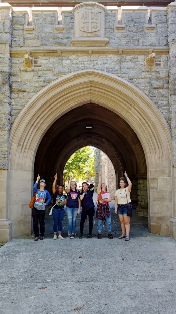 Students in the gothic architecture class pose under cow gargoyles at Virginia Tech