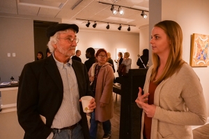 Juror Ken Bova (left) chats with artist Carley Stidham before awards are announced.