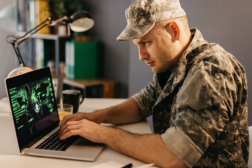 Military serviceman working on a laptop