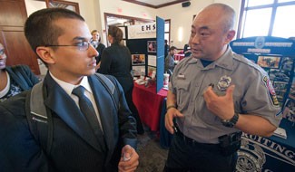 Criminal Justice major Tristan Lora talks with Fairfax Police Department's Roy Choe