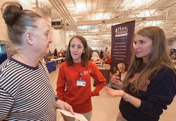 A pair of RU Nursing students consult with a Health Fair visitor. 