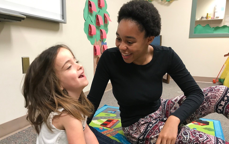 Adaisha Cole, right, greets a child in the Preschool Language Lab.