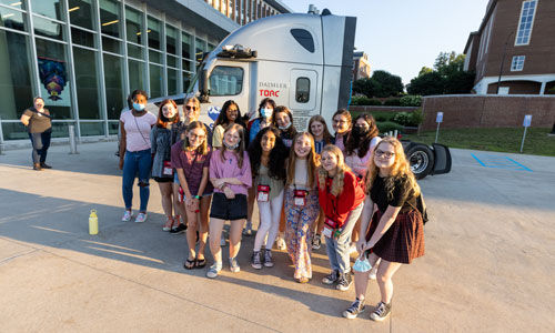 Participants stand in front of a TORC Robotics truck during their camp experience. 