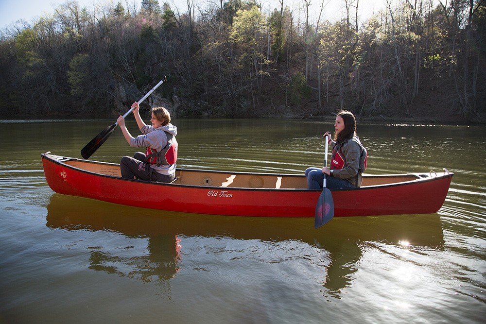 Photo of two students in a canoe, paddling down river