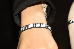 Black wrist band that reads #LivingForAnother