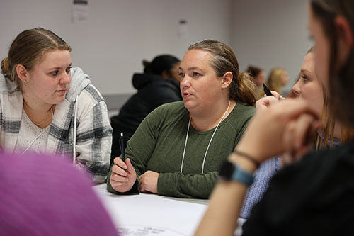 M.S.W. student Melissa Kedrowitsch speaks with team members during the IPE case study activity.