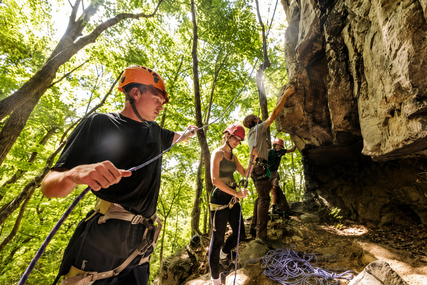three students preparing to rock climb