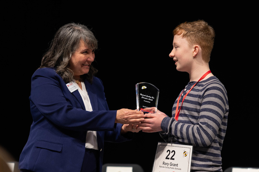 Debora Bays Wilbon of Radford's College of Education and Human Development presents spelling bee winner Rory Grant with his trophy