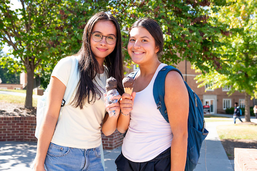 Two students eat ice cream cones they received from attending the 2025 Biz Expo.