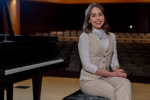 Student pianist and researcher Leah Bratton sits at the piano.
