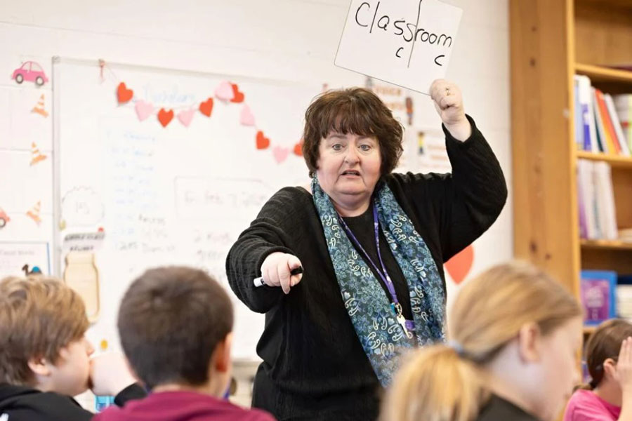 A third grade teacher instructs a classroom full of students