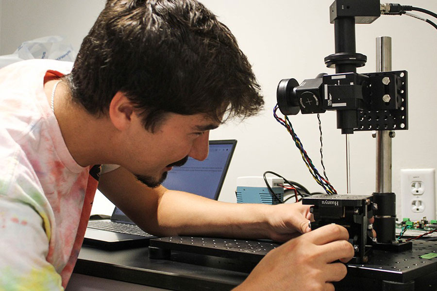 Senior Will Justice magnifies a specimen in a laboratory.