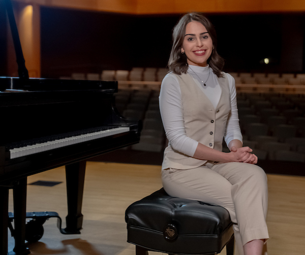 Student pianist and researcher Leah Bratton sits at the piano.