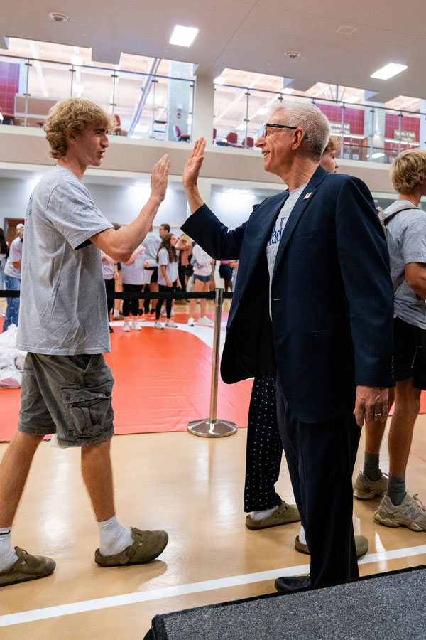 President Bret high fives a student