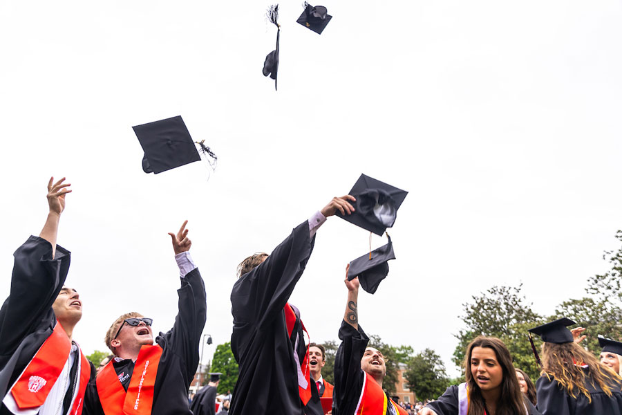 Students graduating from Radford University throw their mortar boards into the air.
