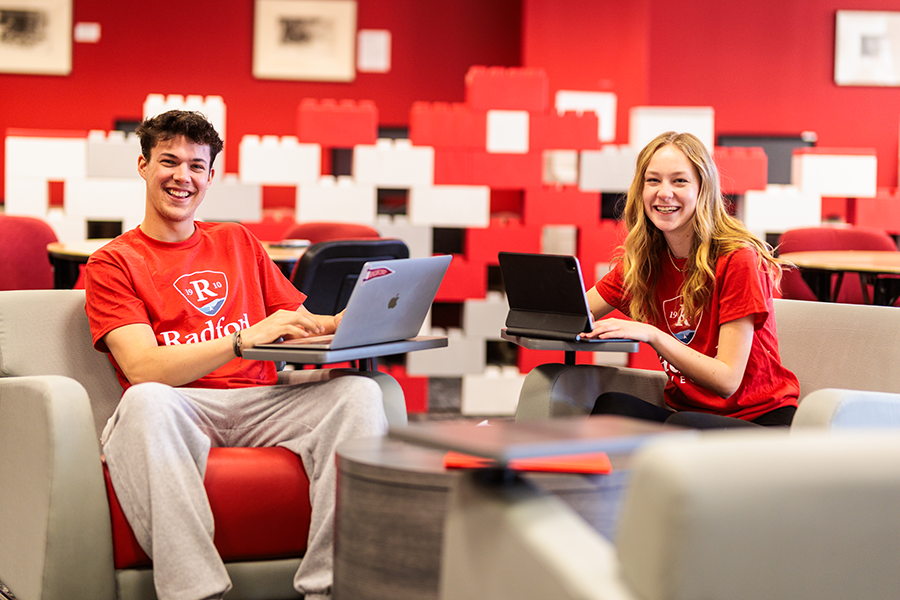 Radford students on computers smiling at camera