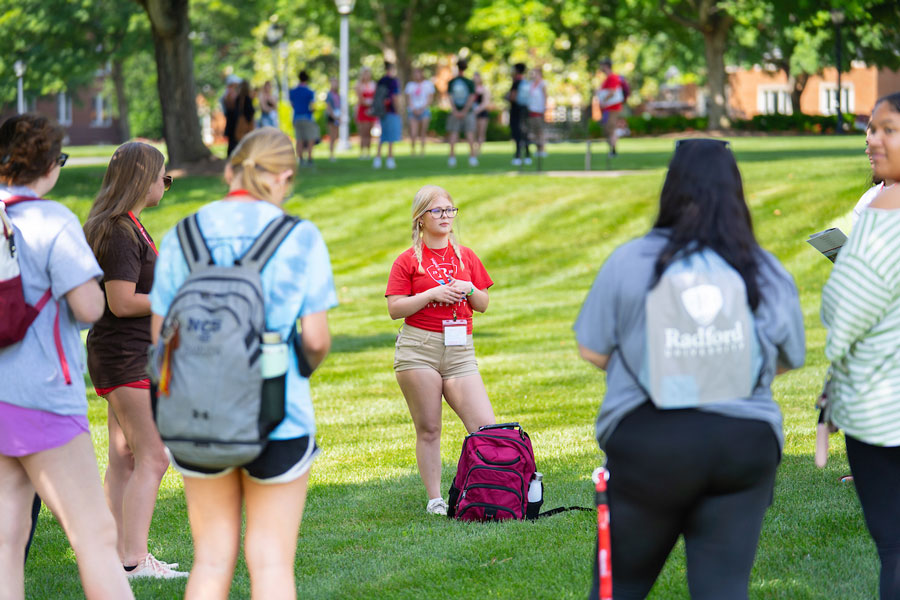 A Quest Assistant begins a tour of Radford University's campus during student orientation.