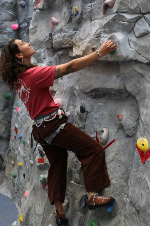 student climbing the rock wall